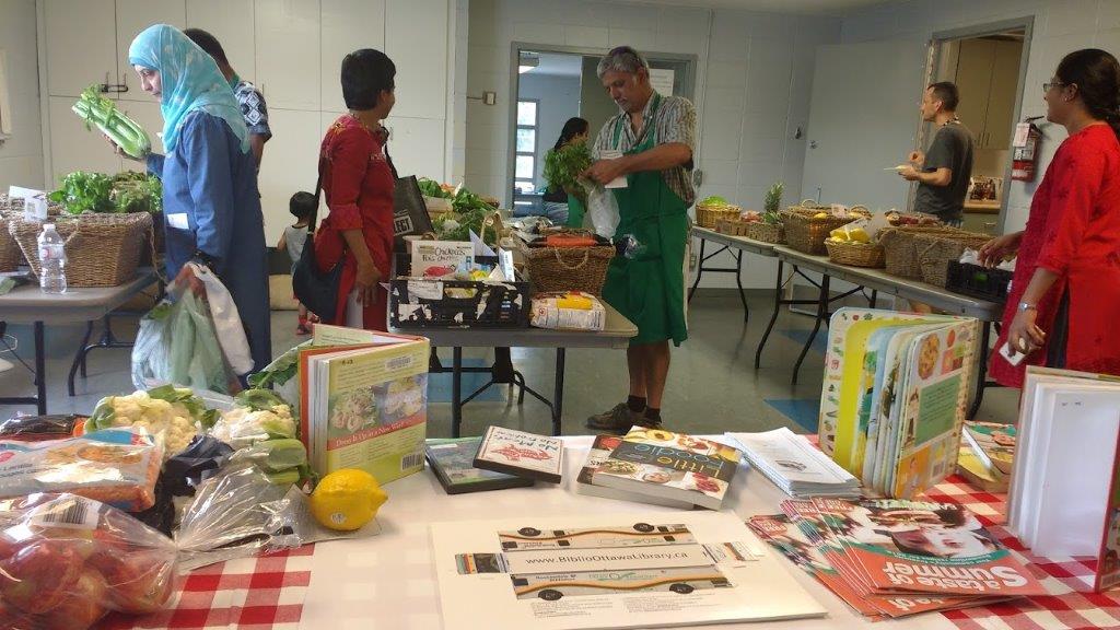 People browsing tables of books and food