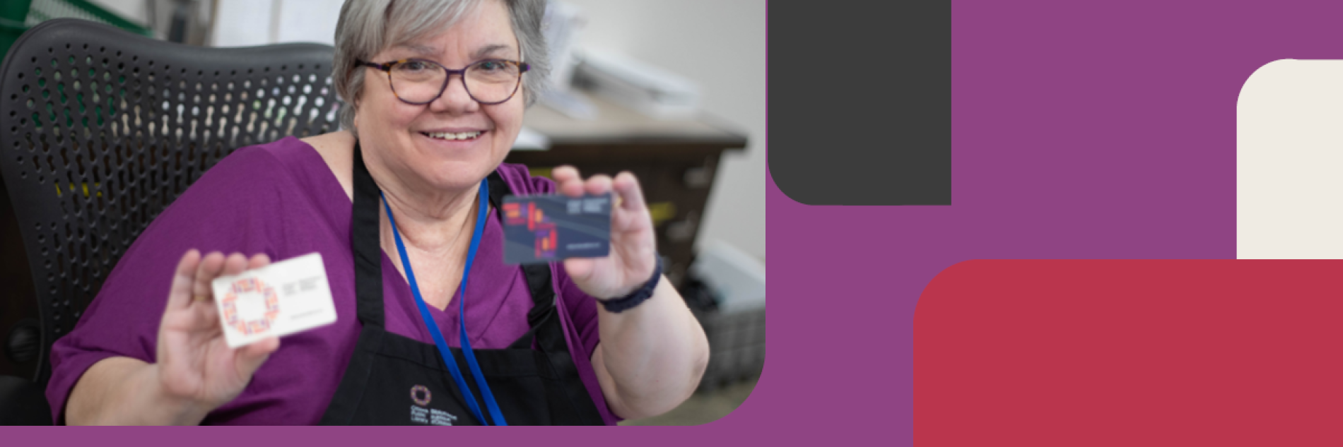 Librarian holding up two library cards with the new OPL brand designs