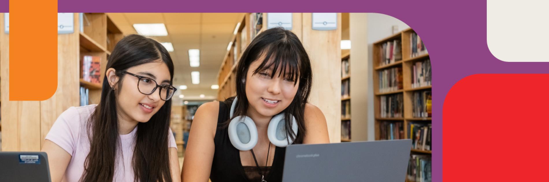 Two young teenagers working on a laptop at the Library.