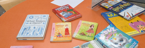 Orange table full of children books / Table de couleur orange remplie de livres d'enfants