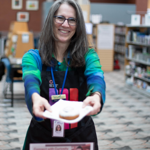Library staffing handing out new branded donuts