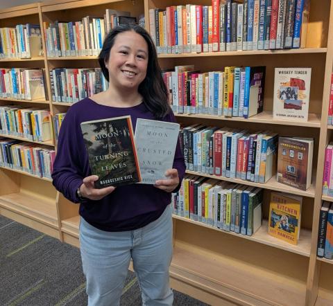 Librarian holding two novels by the author
