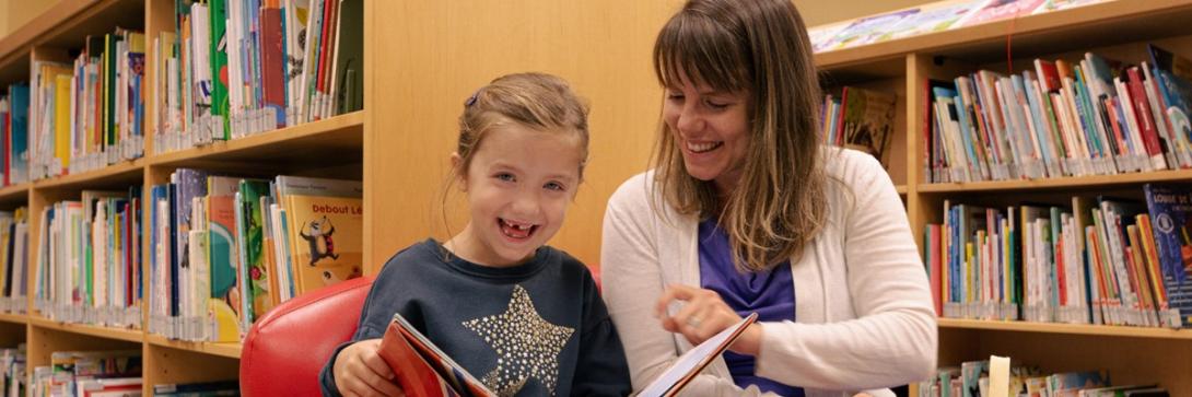 Une femme et une fille lisant un livre à la bibliothèque